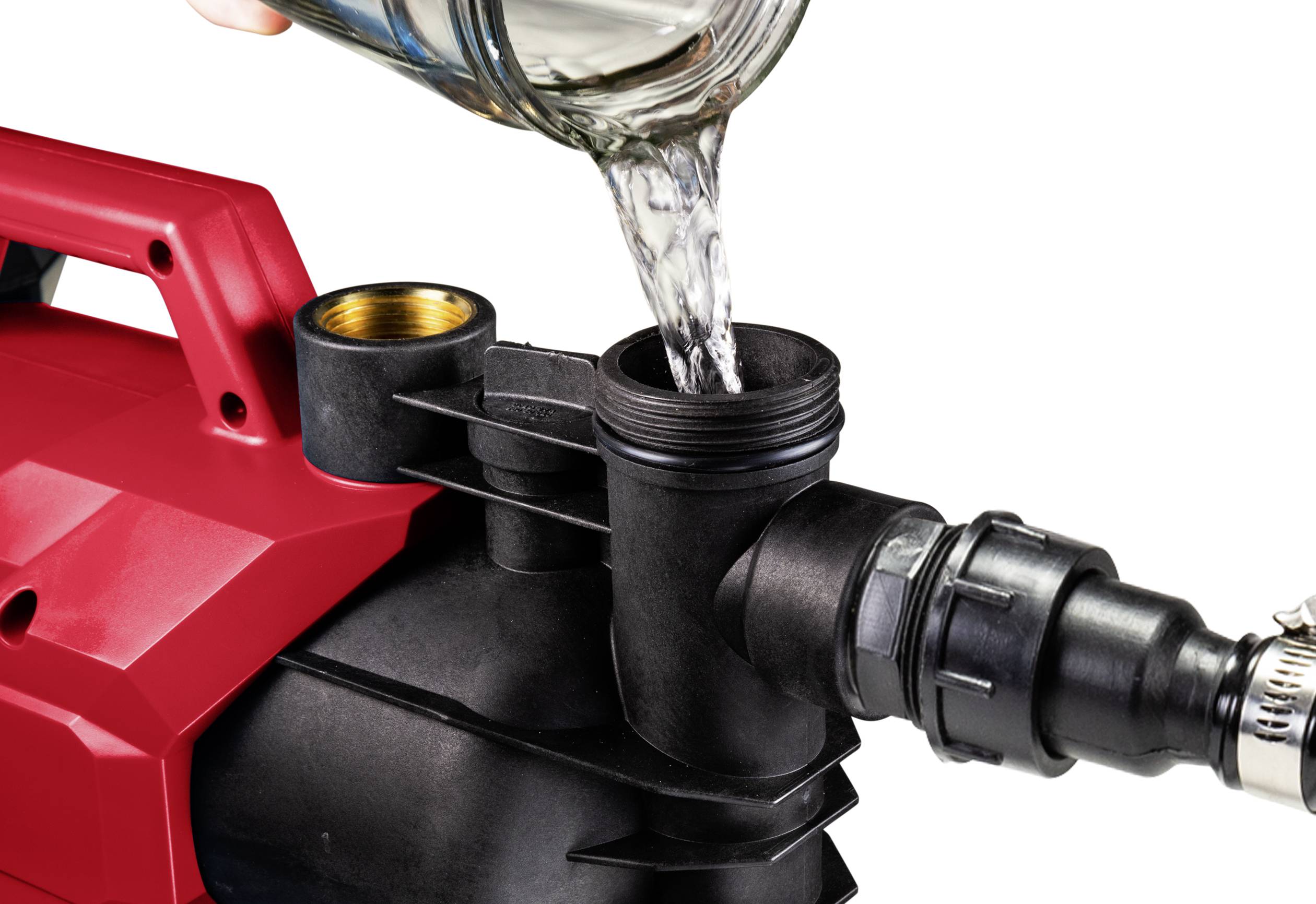 Appareil électrique rouge avec un tuyau noir ; un liquide est versé dans l'ouverture.