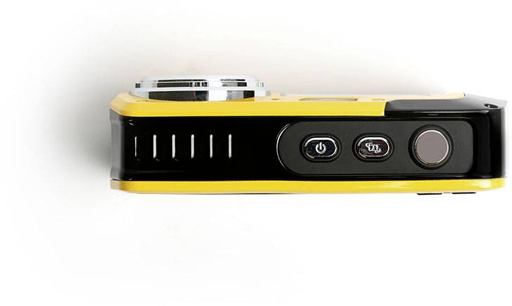Un appareil photo compact jaune et noir est posé avec sa face arrière vers le haut. Deux boutons et un objectif sont visibles.
