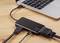 Un ordinateur portable est connecté à un adaptateur noir via plusieurs câbles, prenant en charge HDMI, USB et Ethernet.