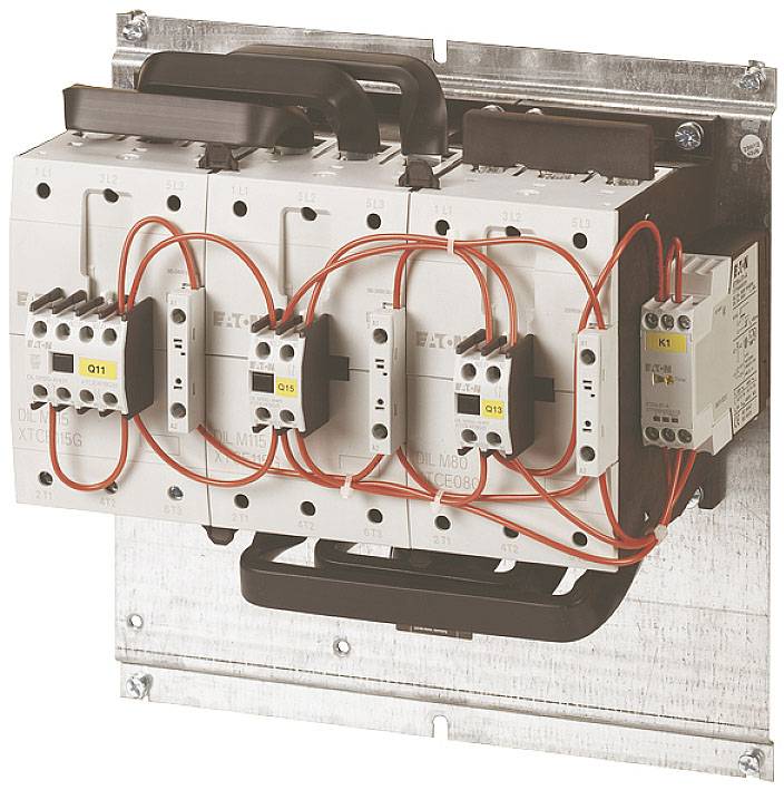 Un armoire électrique avec quatre contacteurs câblés et un module d'automatisation, monté sur une plaque métallique.