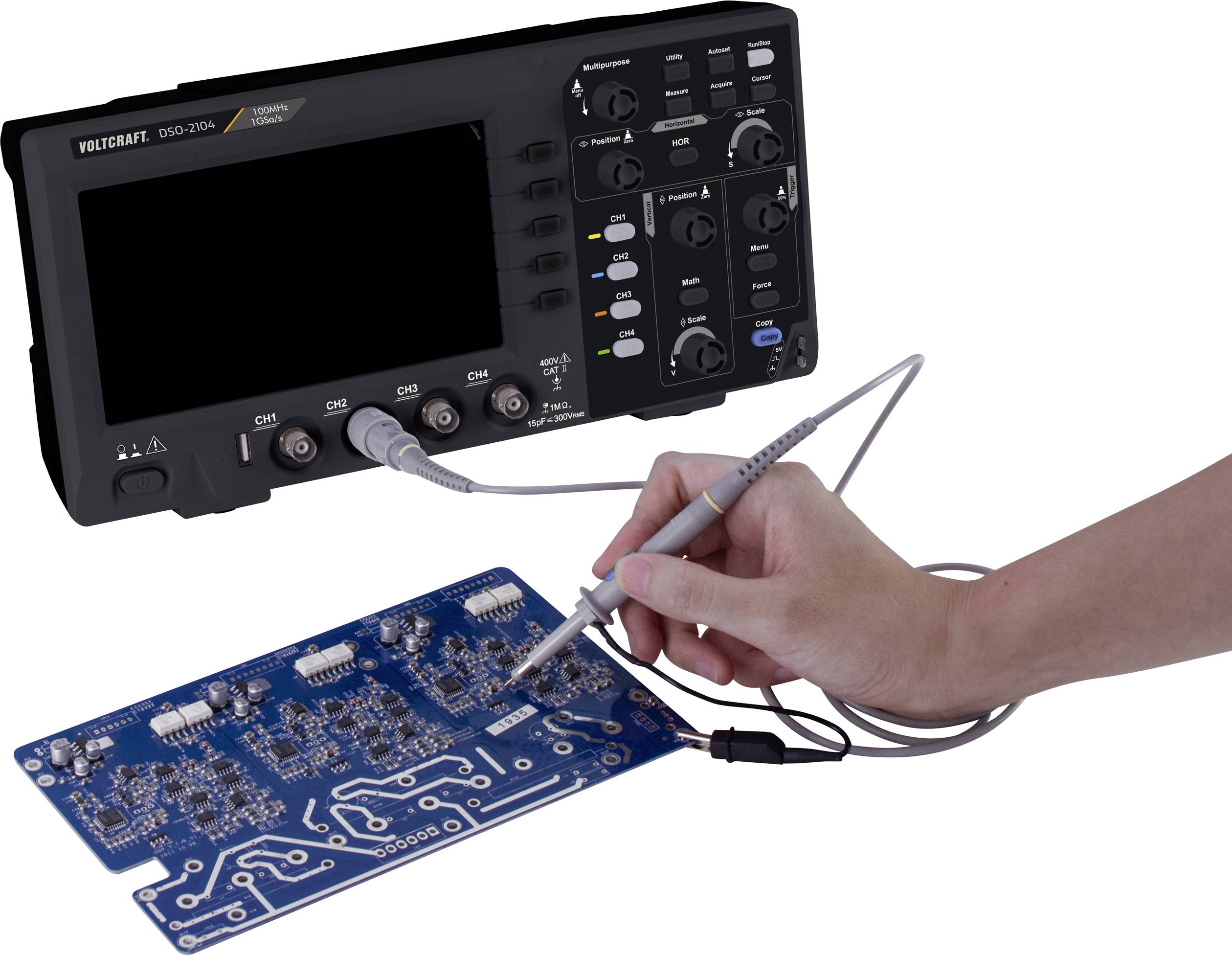 Un oscilloscope numérique mesure des signaux sur un circuit bleu. Une main tient une sonde connectée au circuit.
