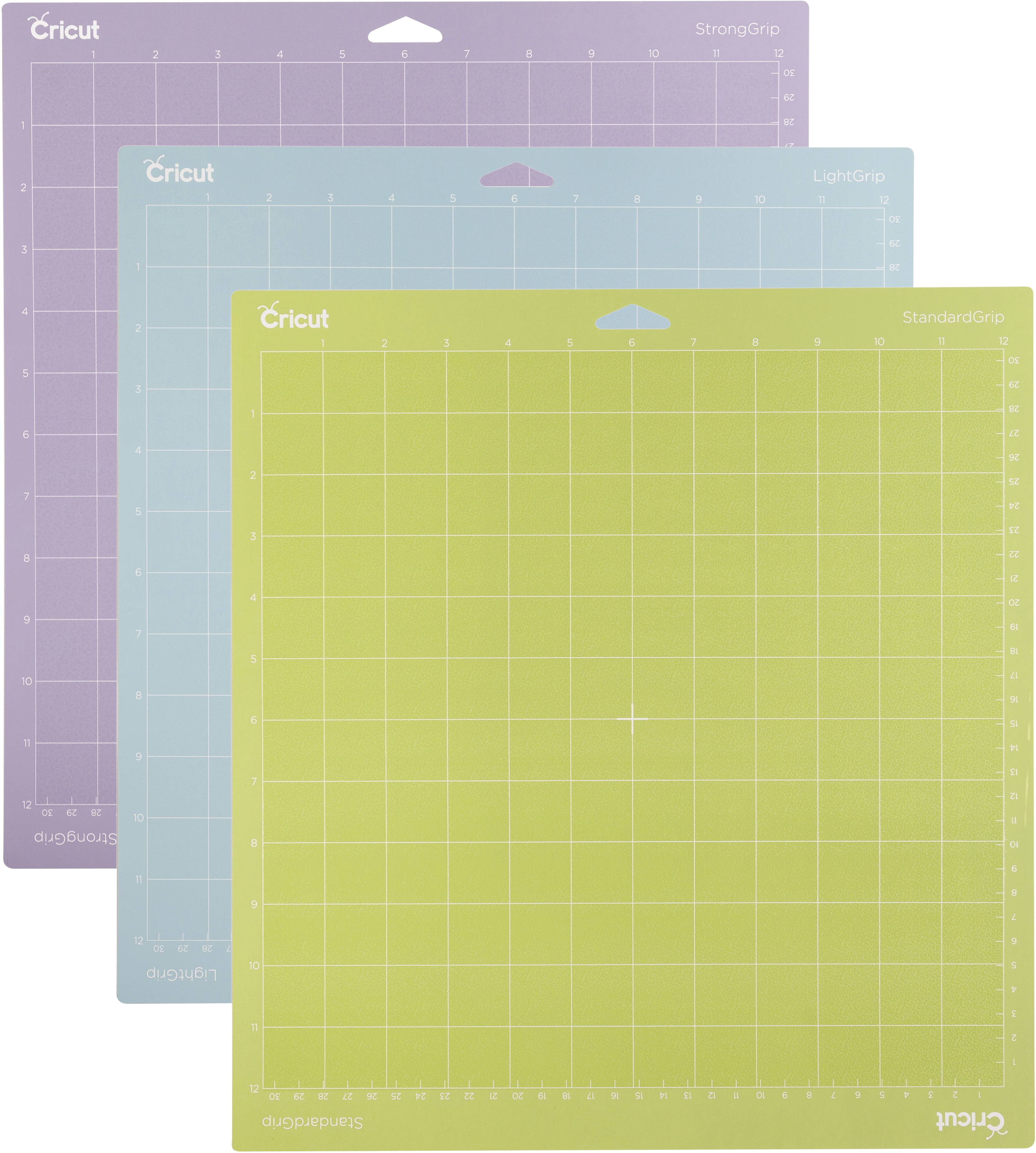 Trois tapis de coupe Cricut de différentes couleurs et adhérences (forte, légère, standard) avec quadrillage pour une coupe précise.