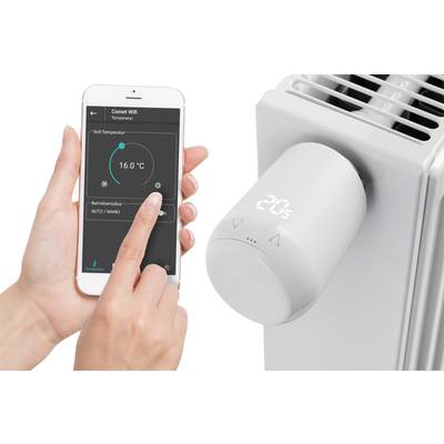 Une main contrôle via une application mobile la température d'un thermostat de radiateur numérique à 16,0 °C.