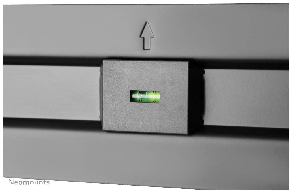 Un niveau à bulle vert avec une flèche indique l'alignement horizontal d'un appareil gris.