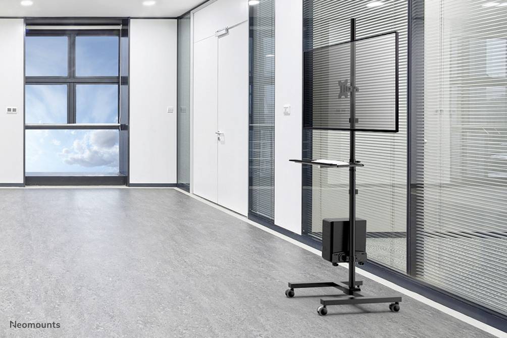 Une salle de réunion moderne avec une grande fenêtre à gauche. À droite, un support d'écran mobile avec un écran incliné et une surface de rangement.