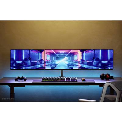 Un bureau de gaming avec trois écrans affiche un jeu futuriste. En dessous, un clavier, une souris et un casque audio sont disposés devant un arrière-plan éclairé.