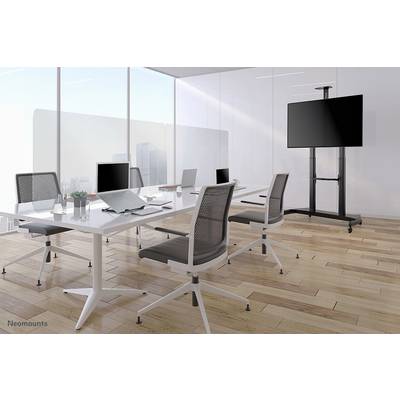 Salle de conférence moderne et lumineuse avec une table blanche, quatre chaises de bureau, un ordinateur portable, un cahier et un écran plat sur support. Vue sur la ville depuis la fenêtre.
