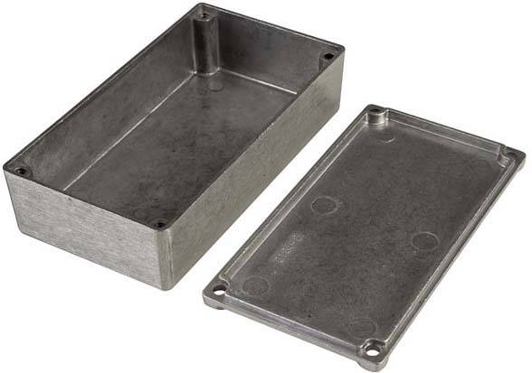 Boîtier métallique avec couvercle retiré, adapté aux appareils électroniques ou aux circuits, montrant des trous de vis aux angles.