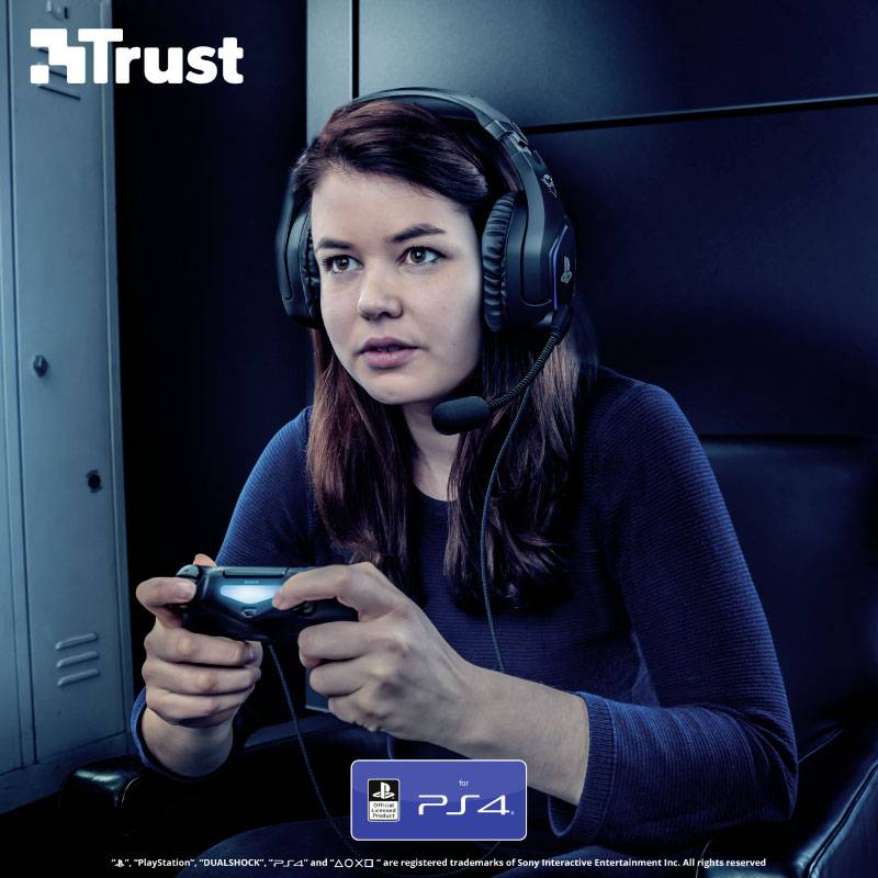 Une femme avec un casque joue concentrée à un jeu vidéo sur une PlayStation 4. En haut à gauche se trouve le mot 'Trust'.