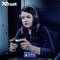 Une femme avec un casque joue concentrée à un jeu vidéo sur une PlayStation 4. En haut à gauche se trouve le mot 'Trust'.