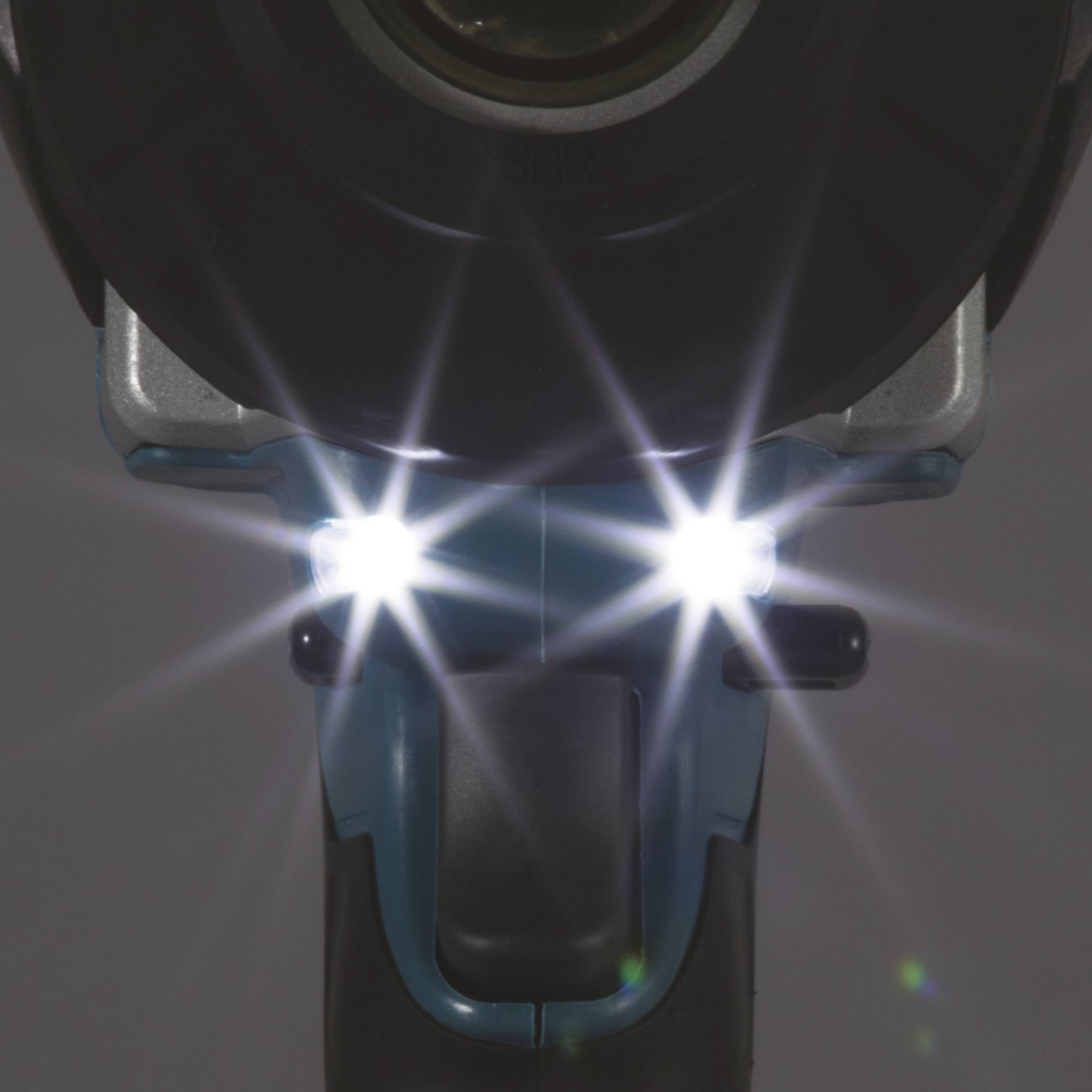 Un outil électrique équipé de deux lumières LED vives à l'avant, illuminant la surface de travail.