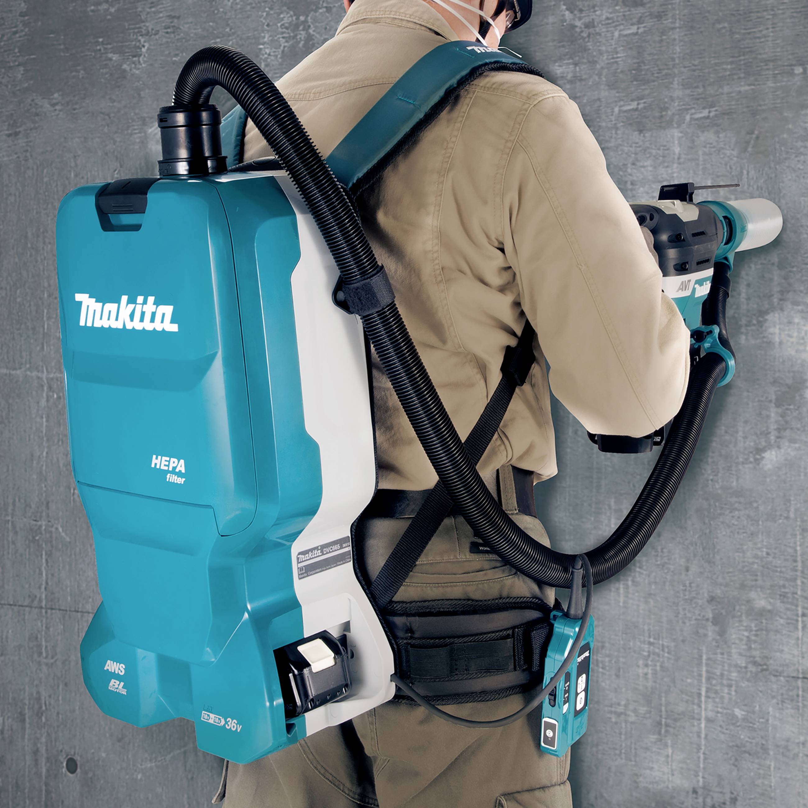 Une personne nettoie une surface avec un aspirateur portable porté sur le dos. L'aspirateur est de la marque Makita et est équipé d'un filtre HEPA.