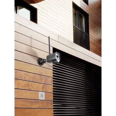 Caméra de surveillance montée sur une façade en bois, surveillant l'entrée d'un bâtiment moderne.