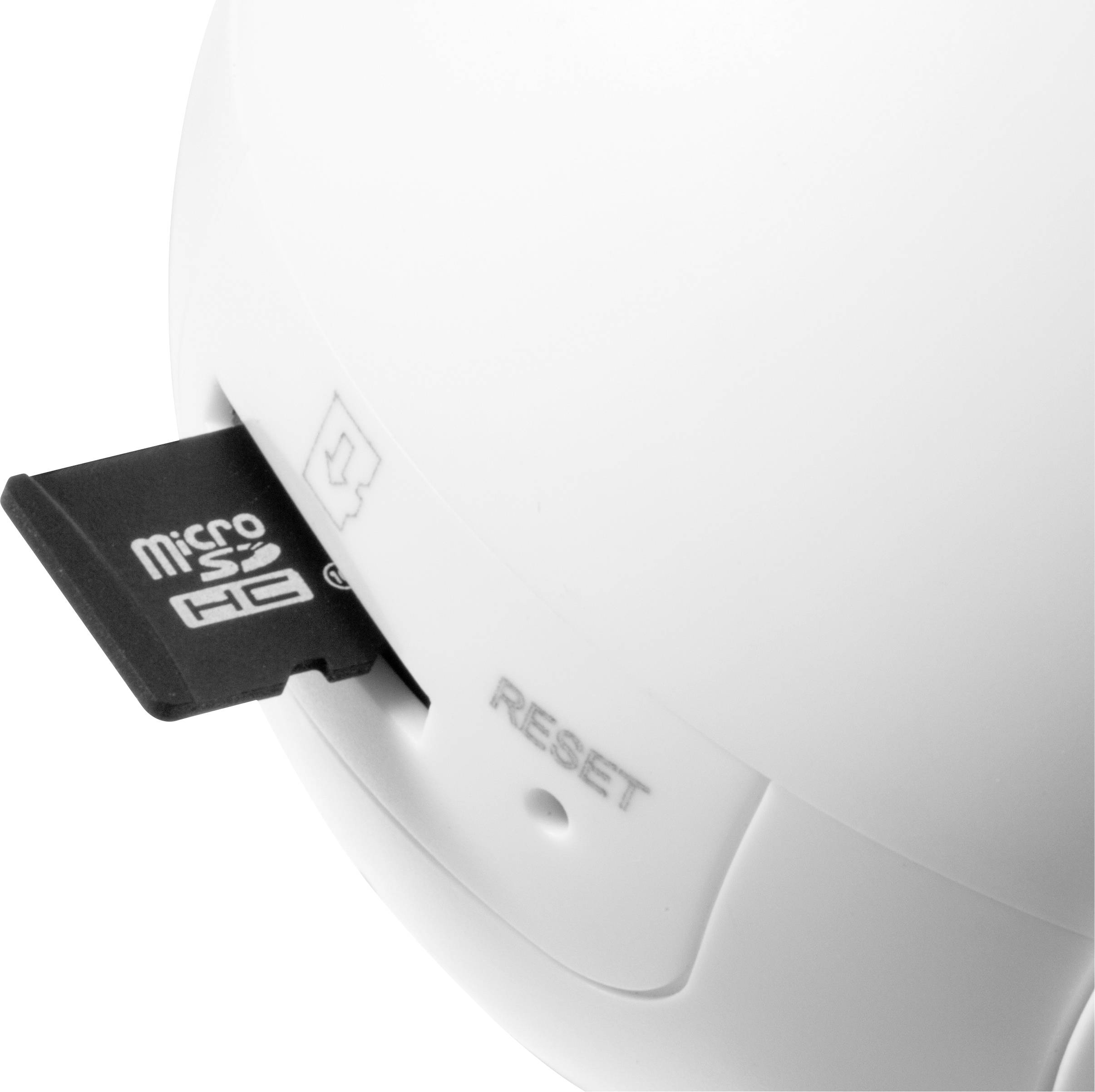 'Gros plan sur le coin d'un boîtier de caméra blanc. Une carte MicroSD est insérée dans la fente à côté d'un bouton de réinitialisation.'