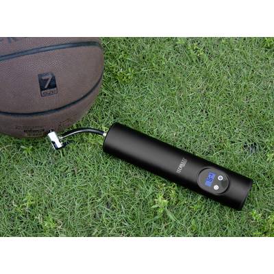 Un ballon de basket est posé sur l'herbe à côté d'une pompe à air électrique noire avec affichage numérique, indiquant une pression de 3,5 bars.