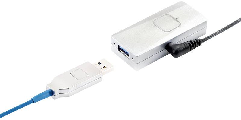 Un périphérique USB argenté avec deux ports, relié par un câble bleu et un câble secteur noir, probablement un adaptateur.