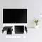 Un bureau avec un ordinateur, une tablette, un smartphone, un clavier et une souris. À droite, une plante et une lampe. Aménagement de bureau moderne.