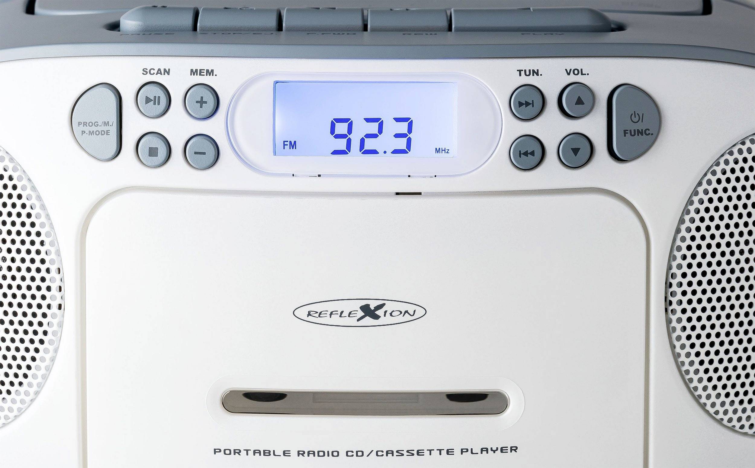 Un poste radio portable avec lecteur de cassettes et affichage indiquant 'FM 92,3 MHz'. Des touches de balayage, volume et fonctions sont visibles.