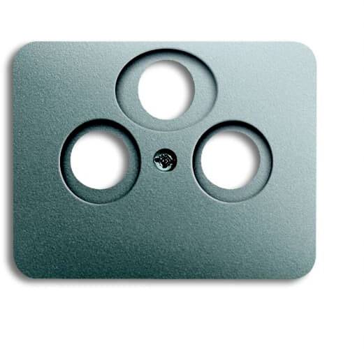 Couverture verte avec trois trous circulaires sur un fond blanc, rappelant un visage stylisé.