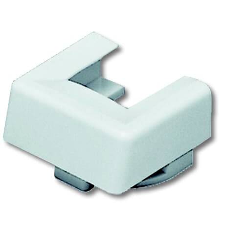 Un angle en plastique blanc et carré est visible, avec une ouverture sur sa surface supérieure.