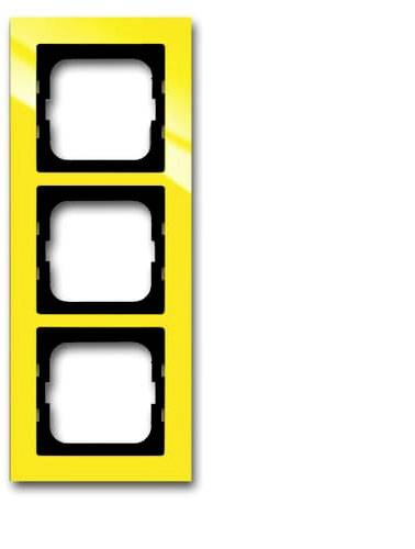 Un cadre de commutateur triple jaune avec des découpes rectangulaires pour accueillir trois interrupteurs, sur un fond blanc.