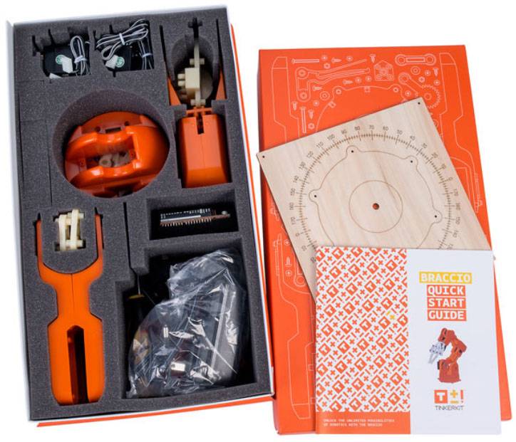 Kit de robot dans une boîte, comprenant des pièces dans des compartiments moulés, un manuel d'instructions et des outils pour assembler le robot.