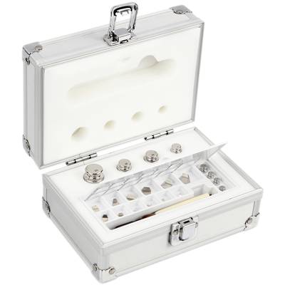 Une valise argentée ouverte avec un intérieur en mousse, contenant divers poids métalliques et accessoires de calibrage.