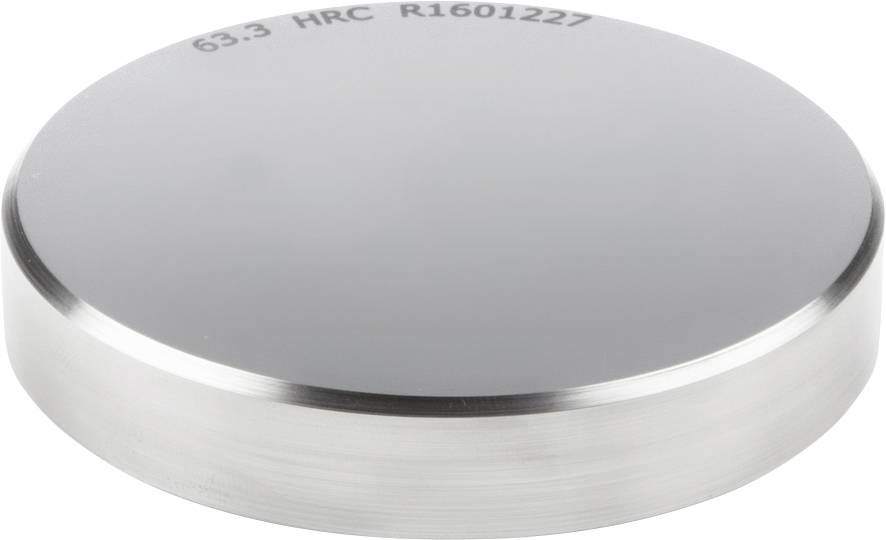 Bloc métallique rond à surface brillante. Gravé au-dessus : '63.3 HRC R1601227'.