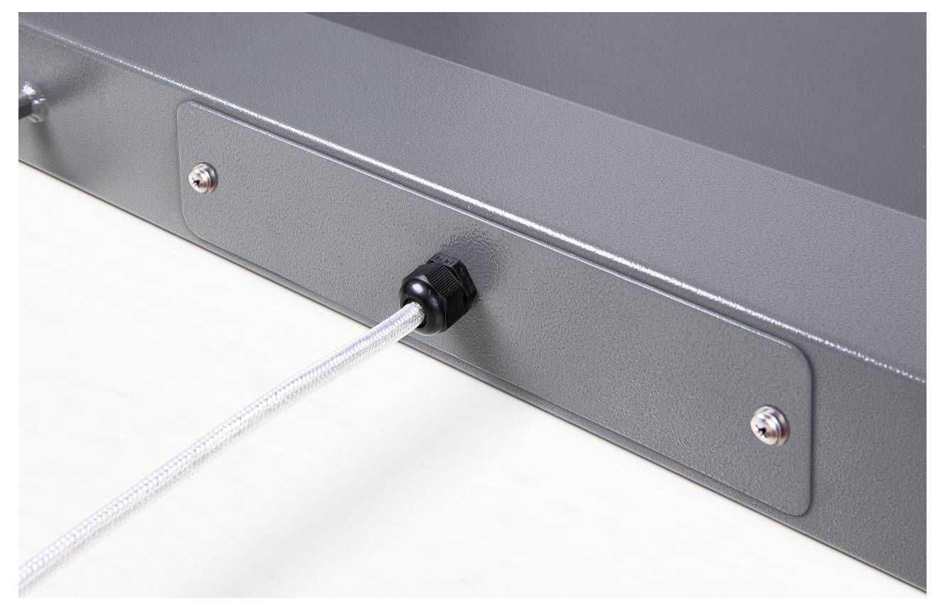 Boîtier métallique gris avec un câble blanc fixé passant par un connecteur noir. Vis visibles.