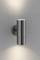 Lampe murale cylindrique moderne en métal projetant des faisceaux lumineux vers le haut et le bas sur un mur gris.