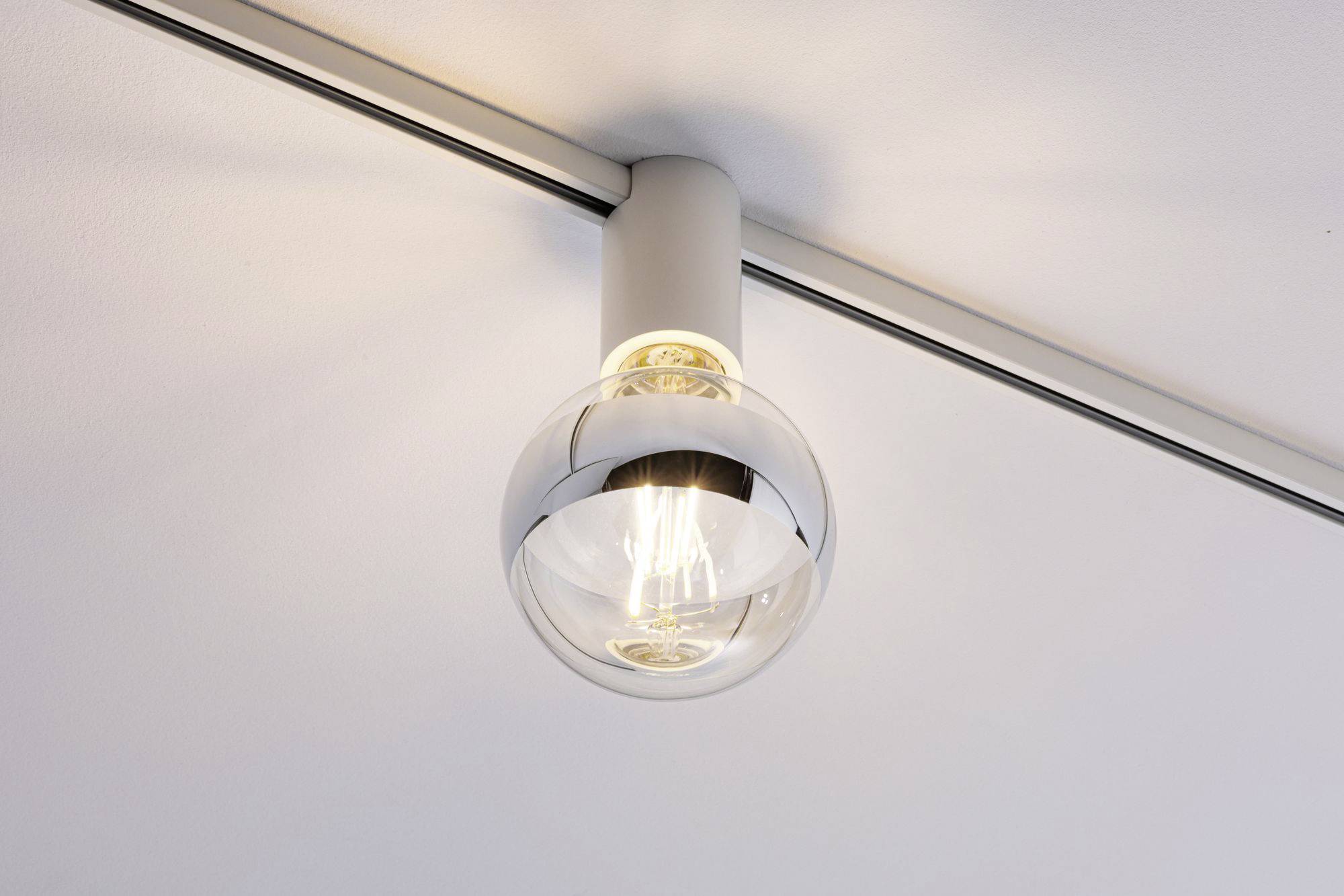 Une ampoule transparente dans un support mural moderne au plafond, lumineuse et fonctionnelle.