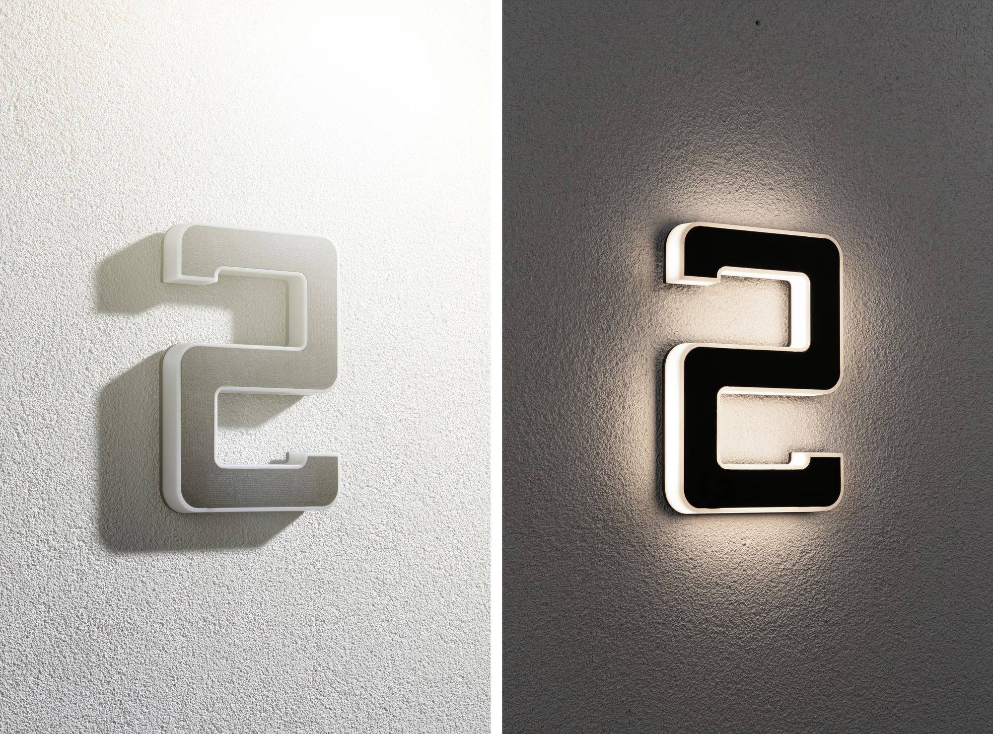 Deux numéros de maison éclairés en forme du chiffre 2, l'un en design argenté et l'autre en design noir, sont fixés au mur.