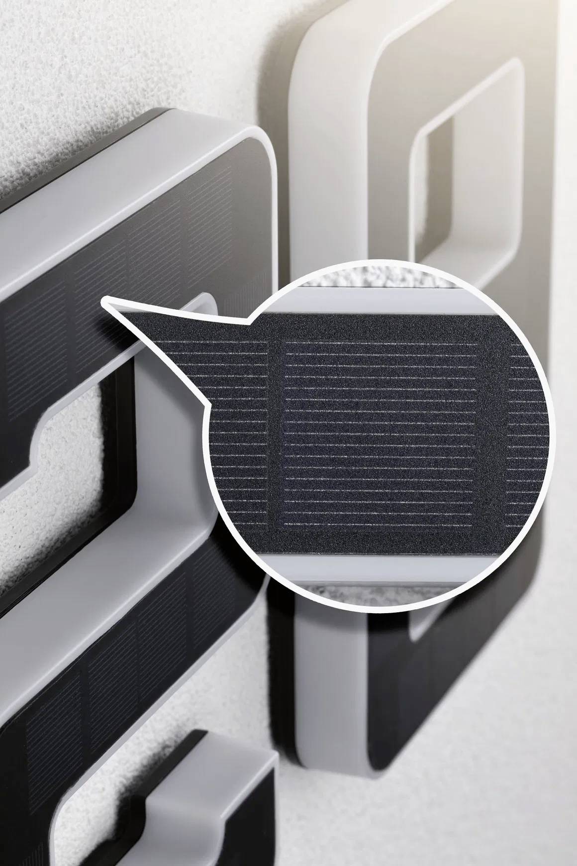 Numéros de maison incurvés avec panneaux solaires intégrés, un gros plan révèle les détails des cellules photovoltaïques. Idéal pour un éclairage extérieur durable.