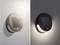Lampe solaire ronde fixée au mur. À gauche avec la lumière du soleil pendant la journée, à droite avec la lampe illuminée la nuit.