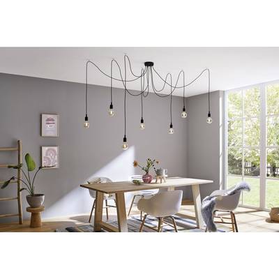 Une salle à manger moderne avec une table en bois, quatre chaises et des suspensions décoratives. La lumière du jour entre par de grandes fenêtres.