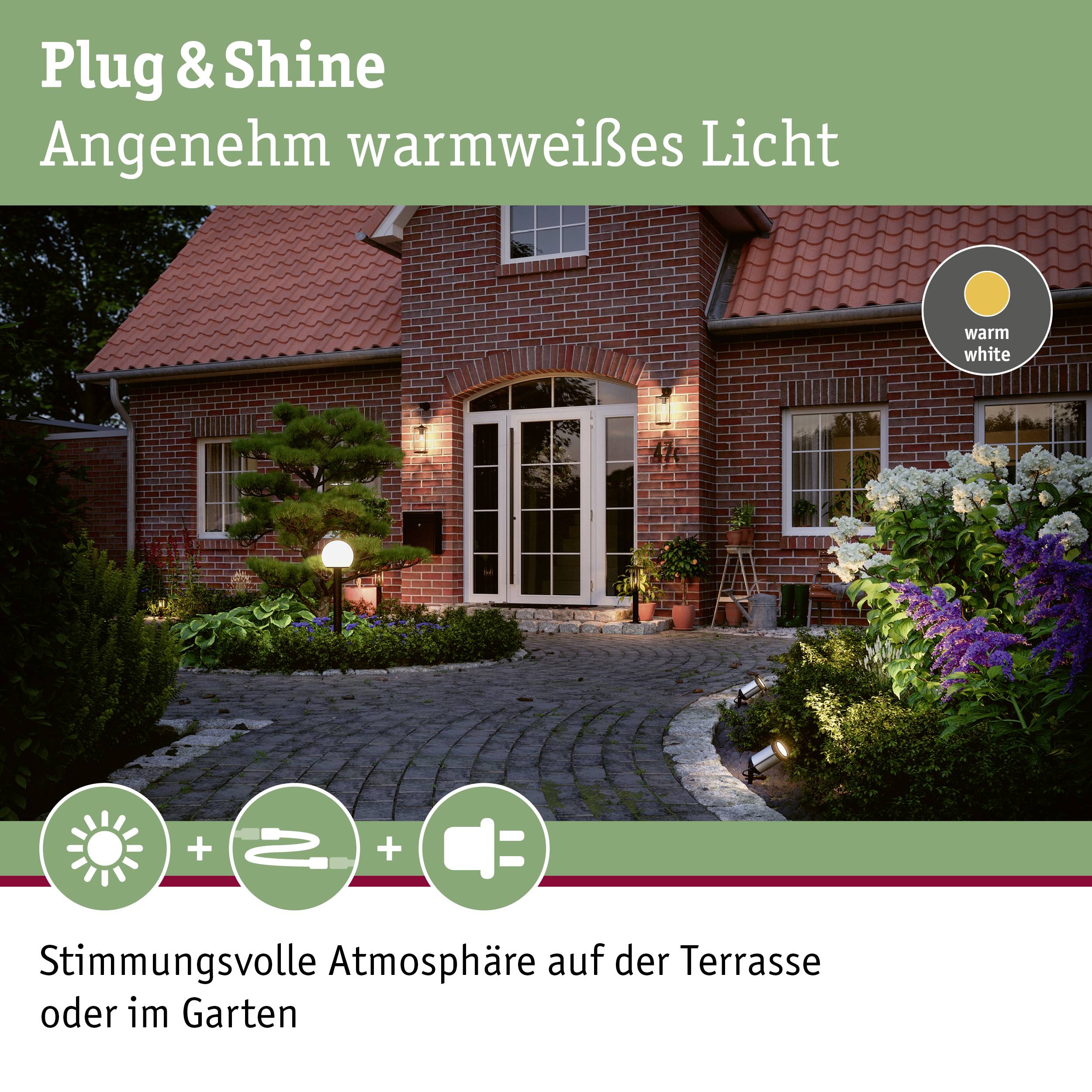 Plug & Shine crée une lumière douce blanc chaud sur une terrasse pavée, avec des arbres et des meubles de jardin. Idéal pour une ambiance de soirée.