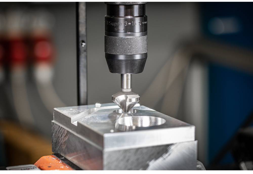 Une machine-outil CNC fraise avec précision un bloc de métal à l'aide d'un outil rotatif dans un environnement d'atelier.