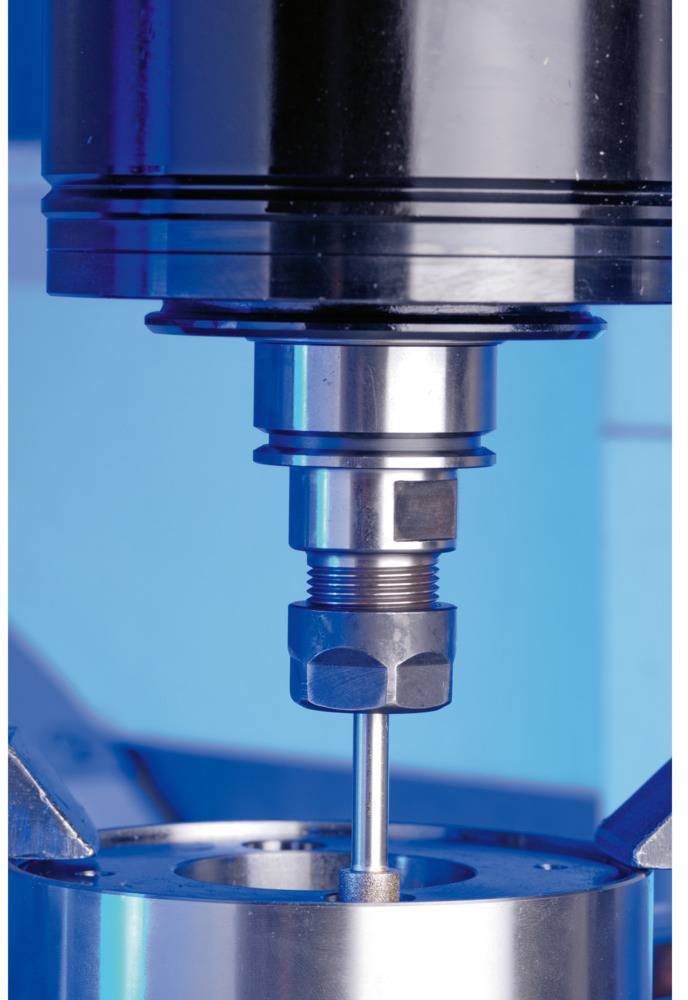 Composant de machine en gros plan, avec des pièces métalliques disposées avec précision, sur un fond bleu.