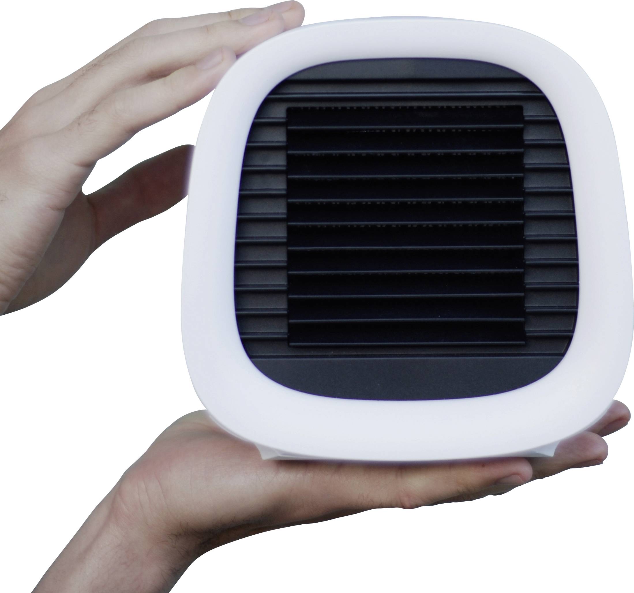 Des mains tiennent un petit ventilateur portable avec une grille noire et un cadre blanc.
