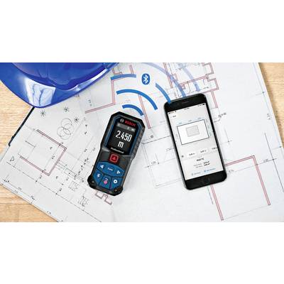 Smartphone et télémètre laser avec plan de construction. Distance affichée sur l'appareil : 2,450 m. Symbole Bluetooth visible.