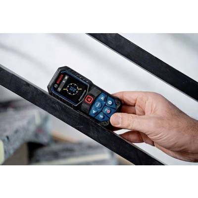 Une main tient un télémètre numérique Bosch posé sur une surface métallique inclinée. L'écran affiche '2,27m'.