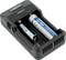 Un chargeur à deux emplacements qui charge une batterie AA et une batterie lithium-ion 18650.