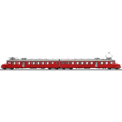 Un train rouge avec deux wagons sur une voie ferrée. Le train a un toit argenté et des caractéristiques ferroviaires classiques.