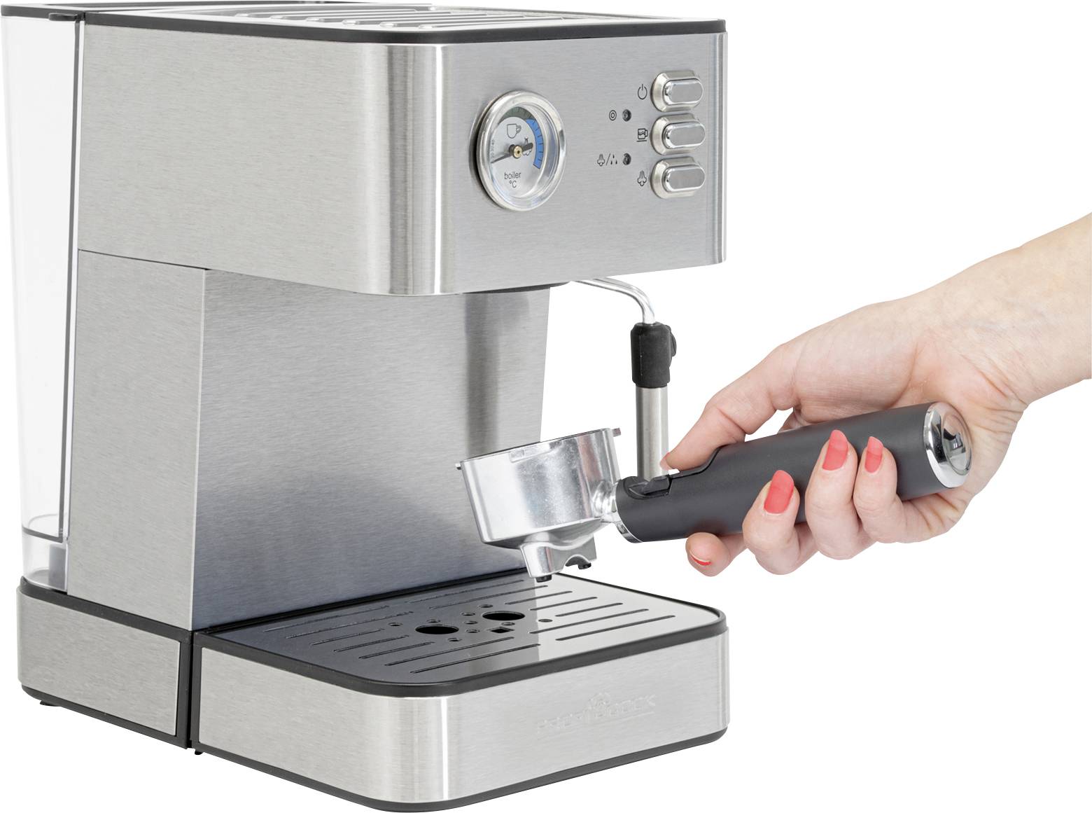 'Une personne tient un porte-filtre à côté d'une machine à espresso argentée.'