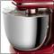 Machine de cuisine rouge avec un bol mélangeur en métal argenté et un couvercle anti-projection transparent, adaptée pour mélanger et pétrir la pâte.
