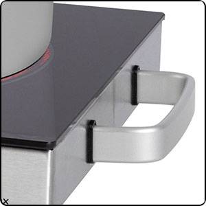 Une poignée carrée argentée est fixée sur le côté d'une plaque de cuisson en vitrocéramique lisse et noire.