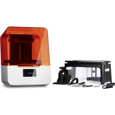 Une imprimante 3D avec un couvercle transparent et des accessoires à côté, comprenant une spatule, une pince et une station de nettoyage.