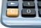 Un gros plan sur un clavier de calculatrice avec le bouton orange 'C' mis en évidence, entouré de touches noires portant des chiffres.