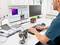 Un homme est assis à un bureau et analyse des données de thermographie sur un écran d'ordinateur. À côté de lui se trouve un appareil de caméra infrarouge.