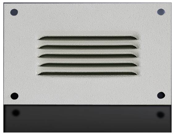 Une grille de ventilation rectangulaire en métal avec cinq fentes horizontales, montée sur une surface lisse de couleur gris clair.